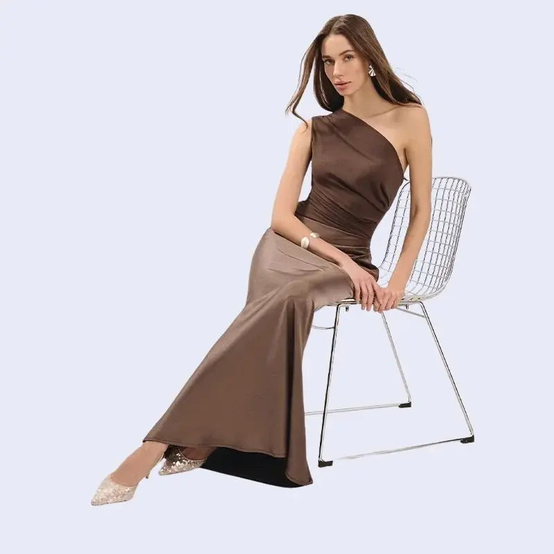 Femme assise portant une robe longue asymétrique en satin couleur chocolat