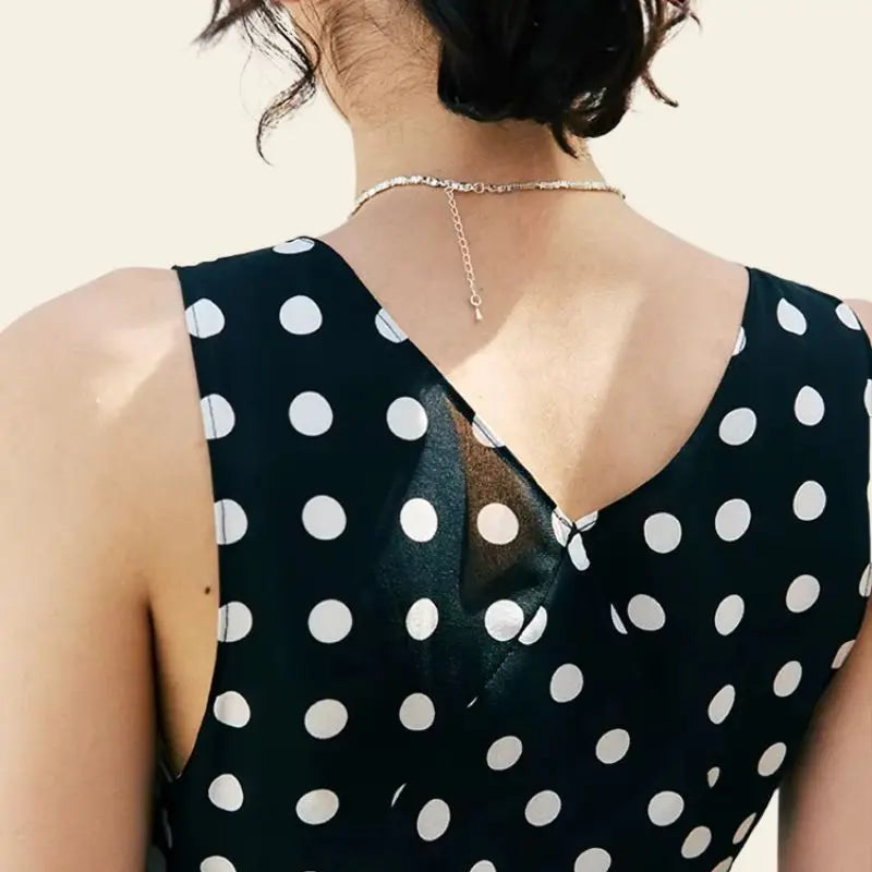 Dos d'une robe longue noire à pois blancs sans manches pure soie