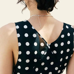 Dos d'une robe longue noire à pois blancs sans manches pure soie