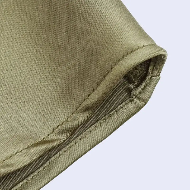 Zoom sur une robe longue sans manches effet plissée en satin couleur kaki