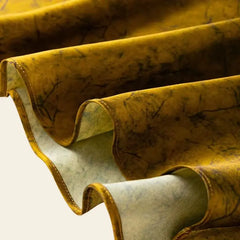 Zoom sur le tissu d'une robe mi-longue dorée motifs imprimés en soie de mûrier