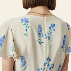 Arrière d'une robe portefeuille mi-longue citron et fleurs bleues pure soie