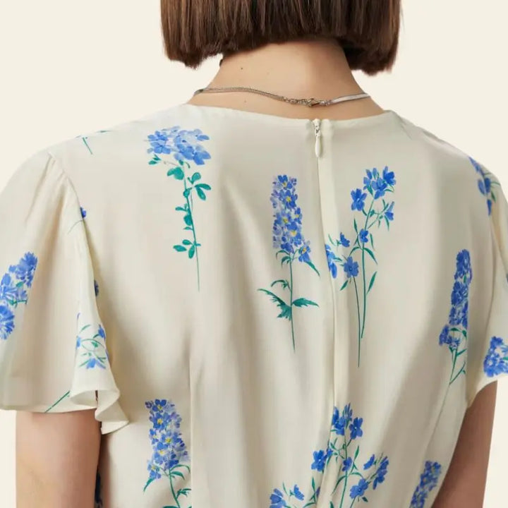 Arrière d'une robe portefeuille mi-longue citron et fleurs bleues pure soie