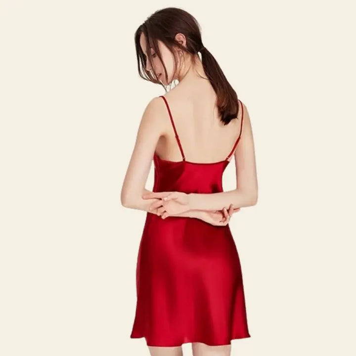 Mannequin de dos portant une robe de nuit courte unie brillante en soie rouge