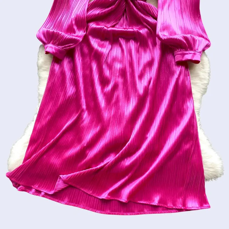 Zoom sur le bas d'une robe de soirée longue avec diamants en satin rose fushia