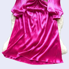 Zoom sur le bas d'une robe de soirée longue avec diamants en satin rose fushia