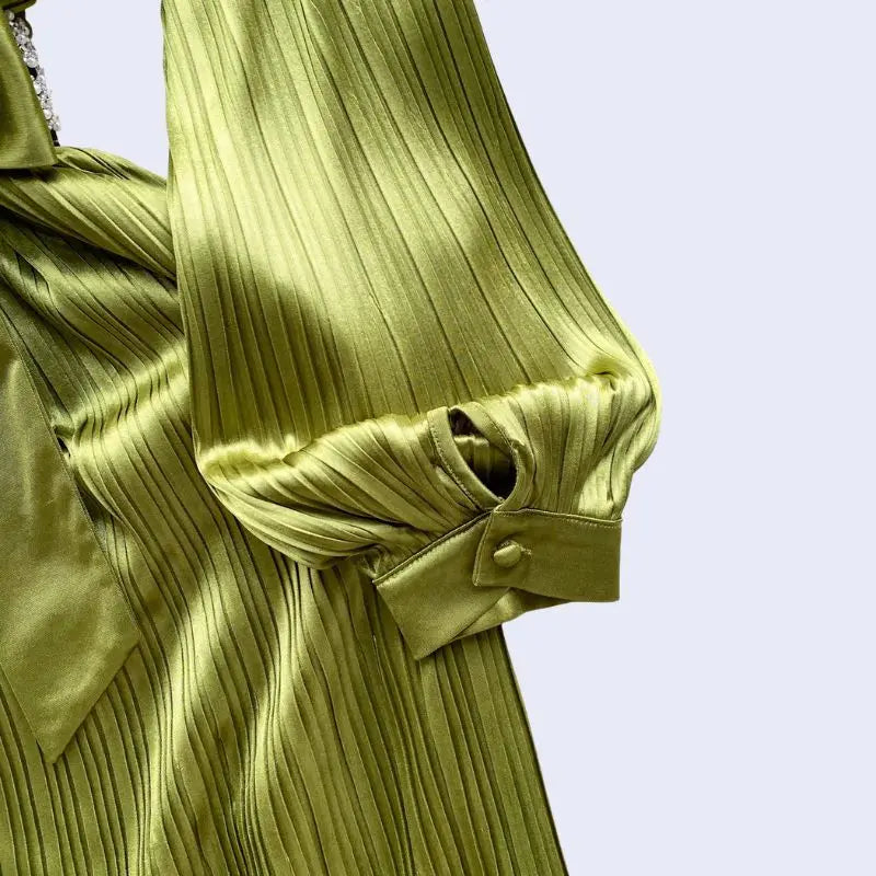 Zoom sur la manche d'une robe de soirée longue avec diamants en satin vert