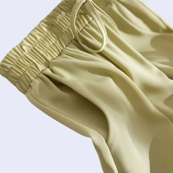 Zoom sur le haut d'un sarouel plissé poches et nœuds en satin jaune olive